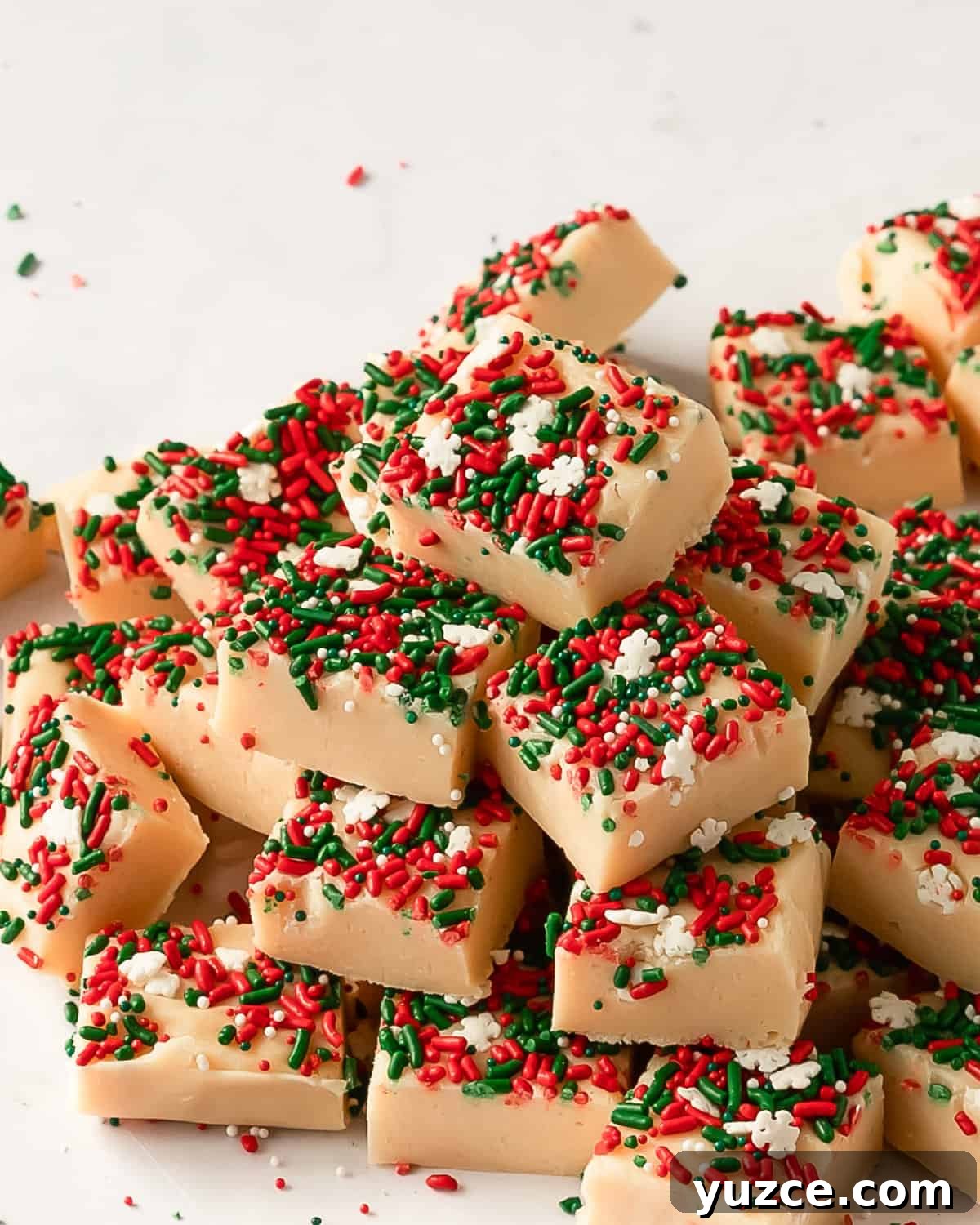 Christmas Cookie Fudge Recipe — Decadent Holiday Treat 2 Christmas cookie fudge on a plate with red and green sprinkles