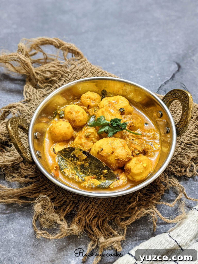Authentic Dum Aloo Recipe: Kashmir-Style Potato Curry Guide 2 Tasty dum aloo curry in a kadhai against a grey background.