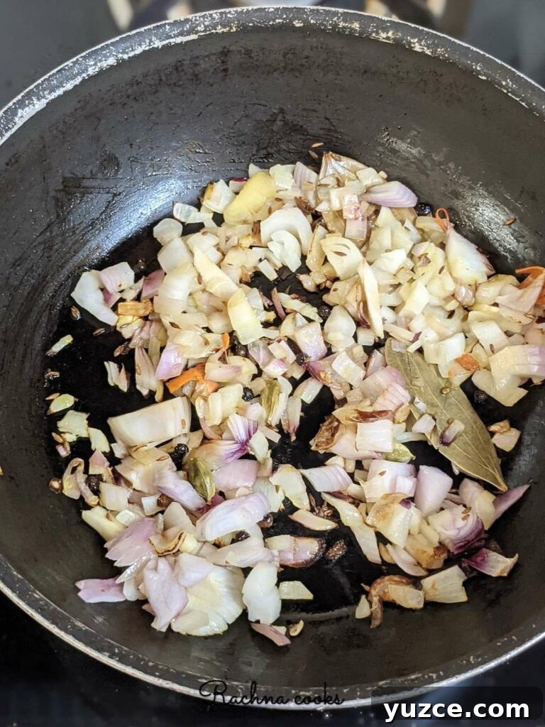 Authentic Dum Aloo Recipe: Kashmir-Style Potato Curry Guide 5 Frying onions and whole garam masala in a pan