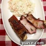 Spicy Maple-Glazed Ribs Recipe for Tangy, Caramelized Flavor 5 Plate with 3 bbq ribs and coleslaw.