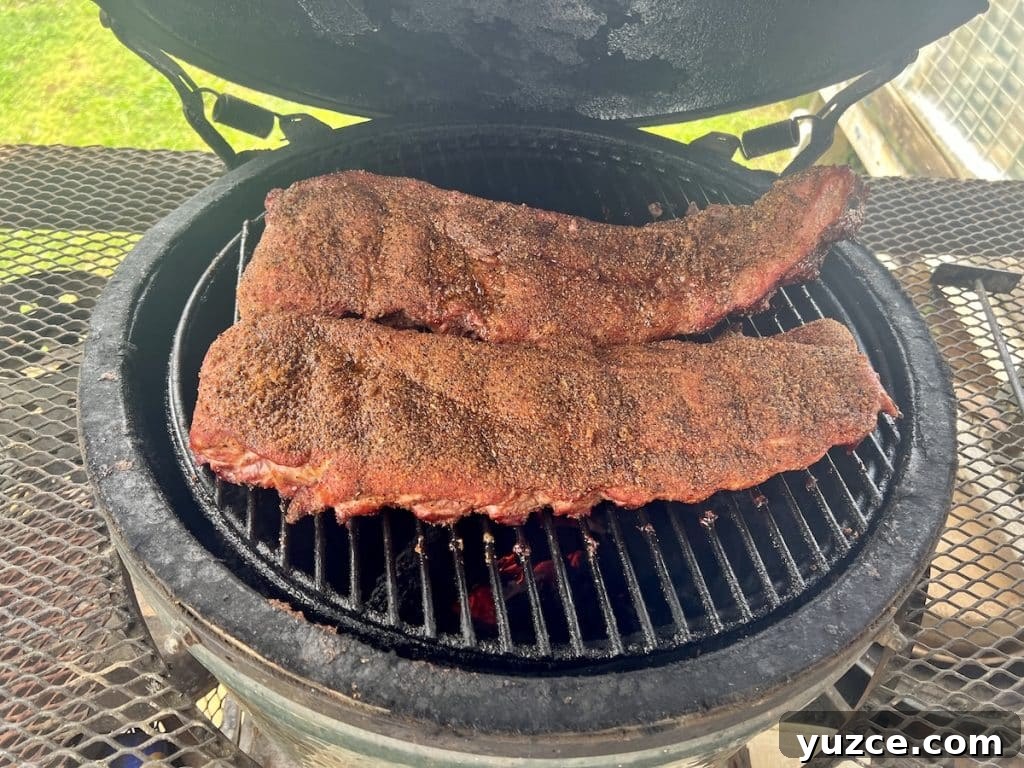 Spicy Maple-Glazed Ribs Recipe for Tangy, Caramelized Flavor 4 Smoked racks of ribs on grill.