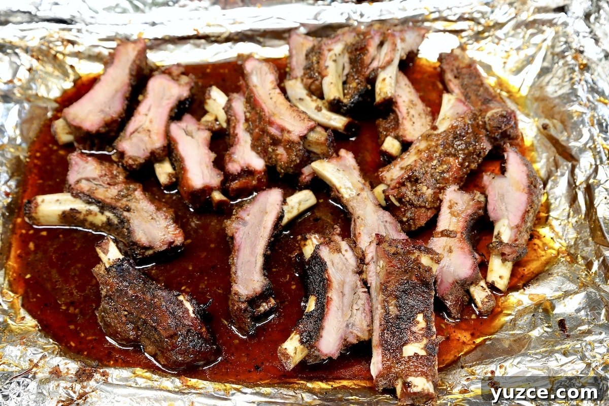 Tender pork ribs with hot maple glaze. Sliced ribs on a foil lined pan.