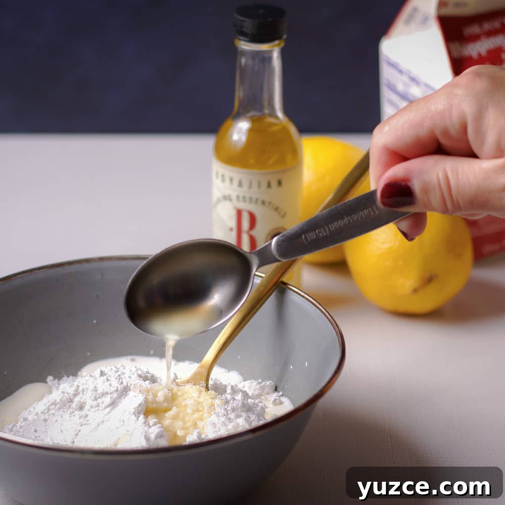 Lemon Glaze Recipe: Quick Zesty Icing for Cakes & Cookies 5 Someone pouring a tablespoon of lemon juice into a bowl of powdered sugar.
