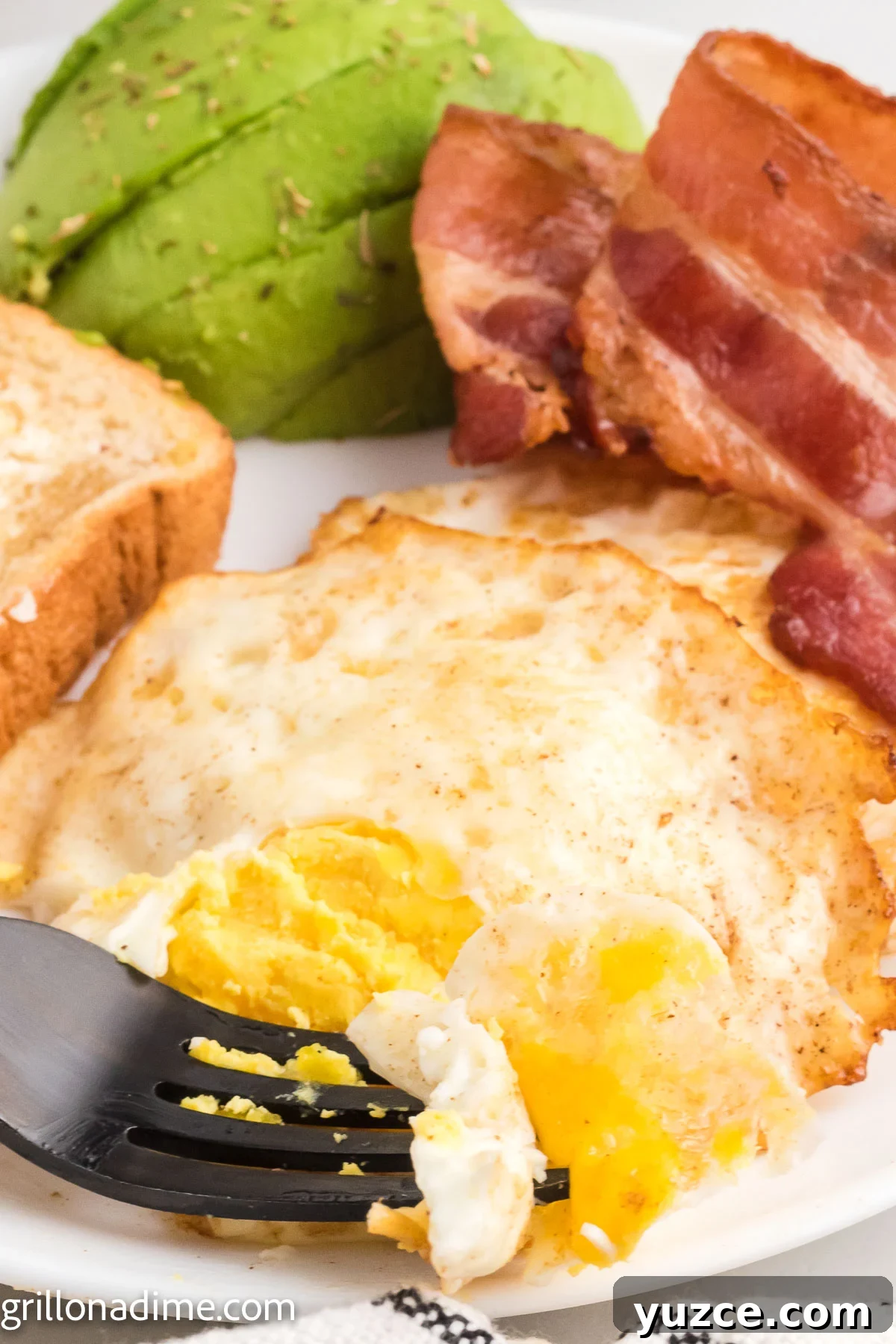 How to Make Over-Hard Eggs on a Blackstone Griddle 8 Over Hard Eggs on a plate with bacon and toast