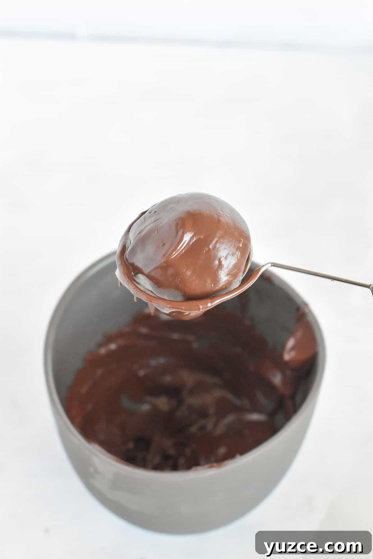 Decadent Chocolate Orange Truffle Recipe for Giftable Sweets 7 truffle being dipped in white chocolate.