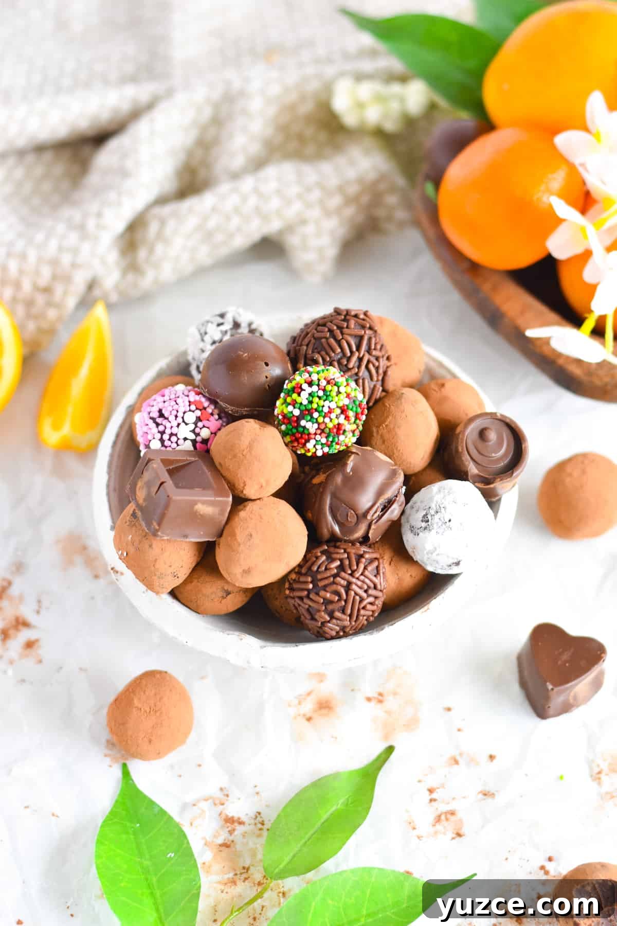 Decadent Chocolate Orange Truffle Recipe for Giftable Sweets 6 truffles piled in a bowl coated in different things.