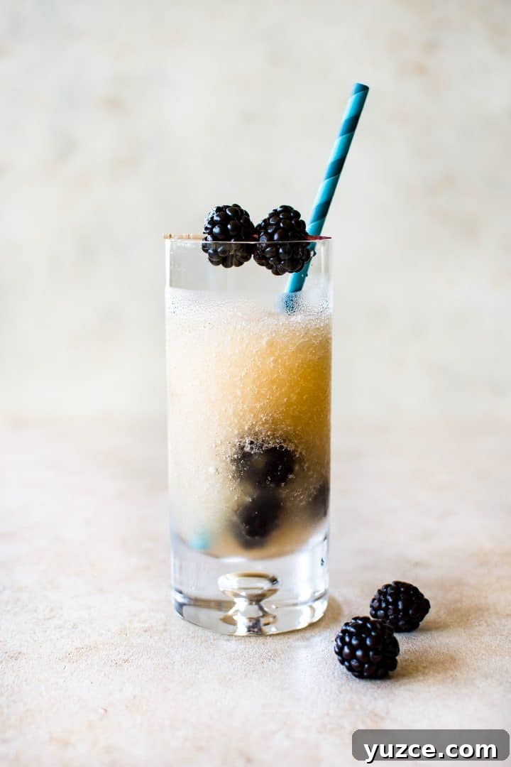 Blackberry Riesling Ice Pops — Frozen Riesling Popsicles 3 a tall clear glass of frozen riesling (friesling) and a blue paper straw