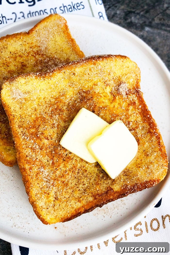 Cinnamon French Toast Recipe: Fluffy Morning Classic 2 Easy Cinnamon French Toast on White Plate Topped with Sliced Butter
