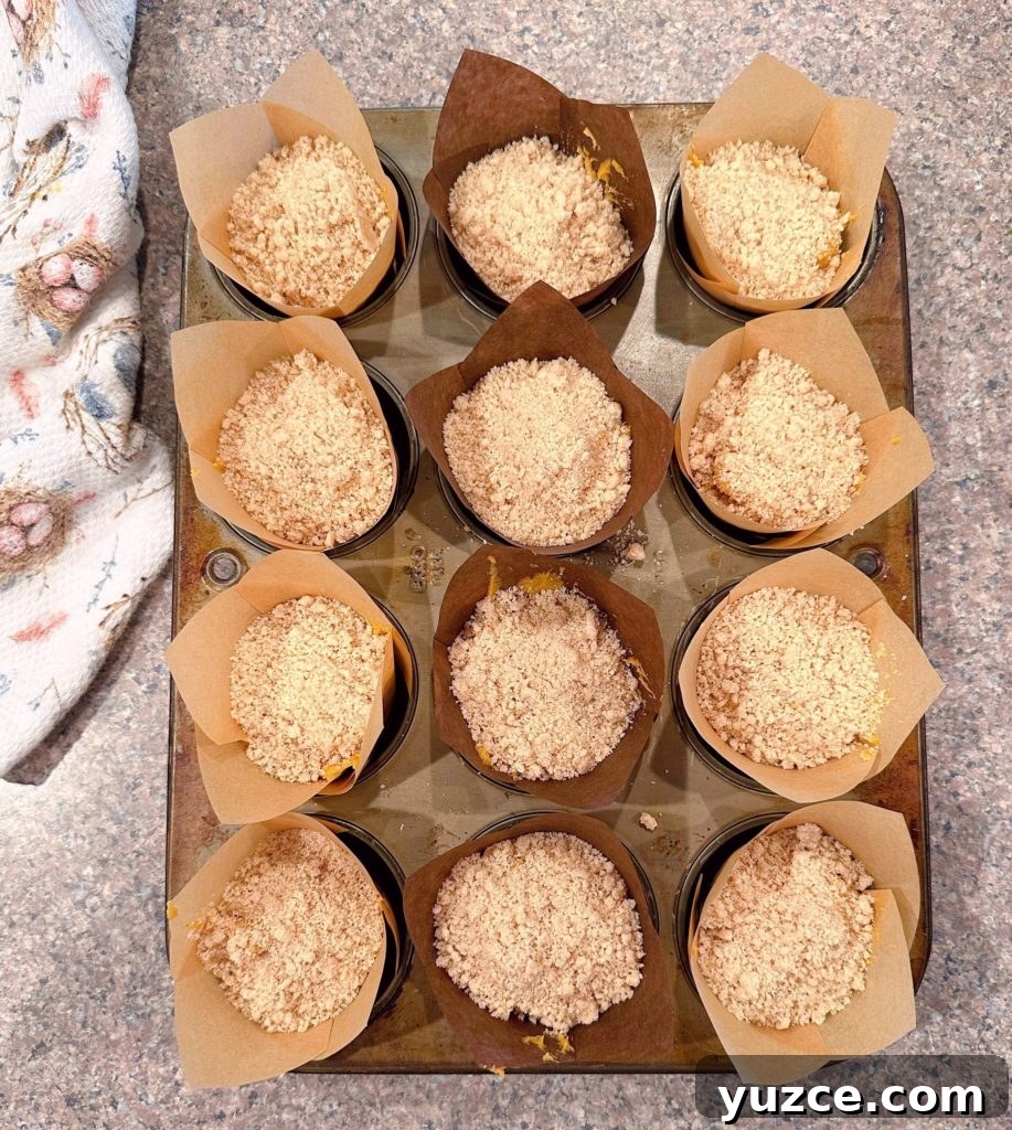 Pumpkin Streusel Muffins with Cinnamon Crumble 8 Muffins sprinkled with streusel topping ready to go into the oven.