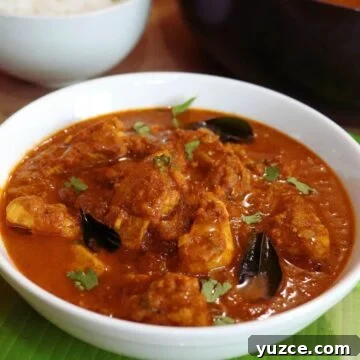 madras chicken served in a white bowl.