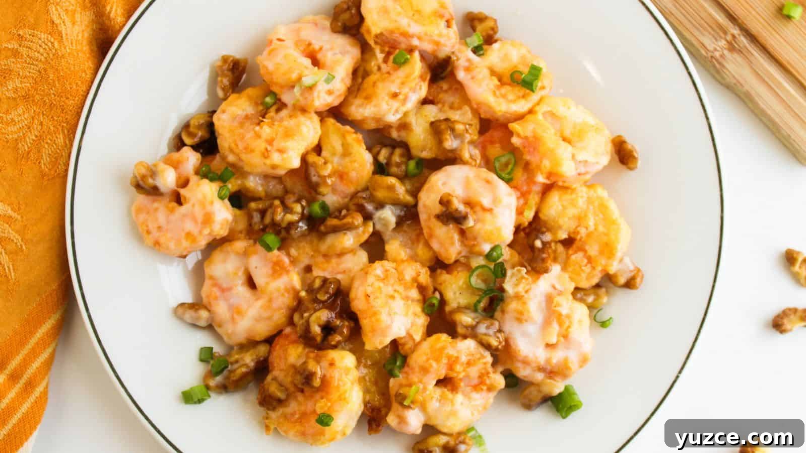 A plate of honey walnut shrimp topped with green onions.