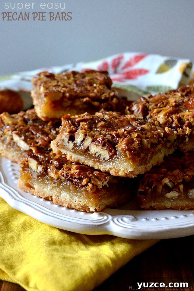 pecan pie bars stacked on white plate and yellow cloth