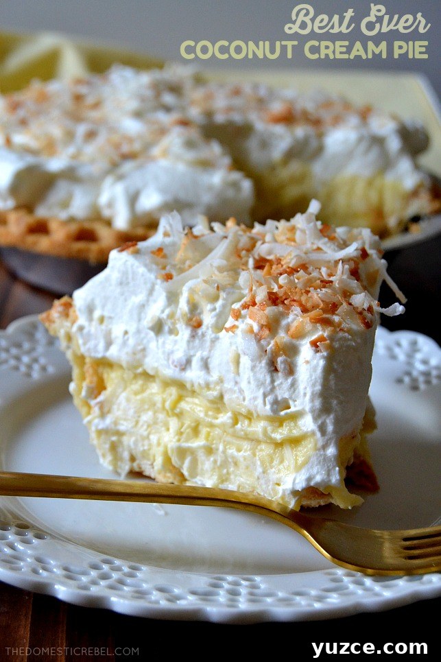 coconut cream pie slice on white lace plate with gold fork