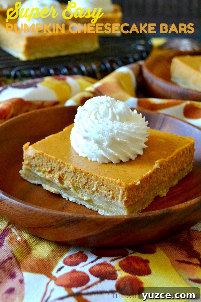pumpkin cheesecake bars on wooden plate and fall inspired cloth