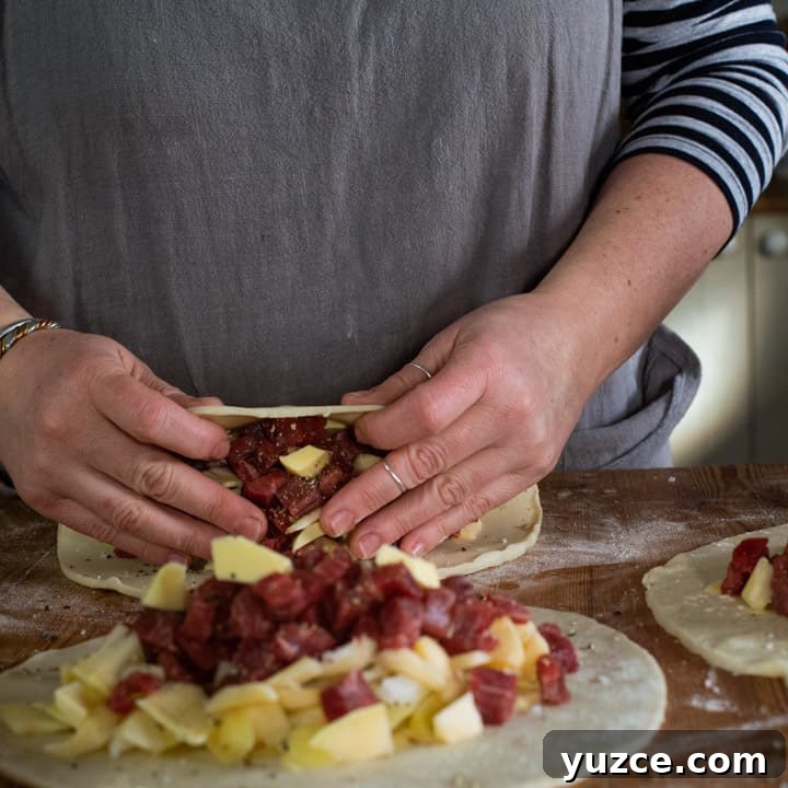 Authentic Cornish Pasty Recipe: Traditional Step-by-Step Guide 10 womans hands folding pastry over pasty fillings read to crimp