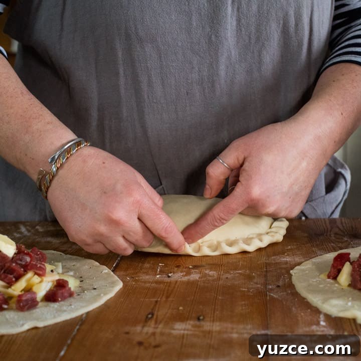 Authentic Cornish Pasty Recipe: Traditional Step-by-Step Guide 12 Womans hands crimping the crust of a traditional Cornish pasty