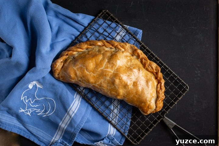 Authentic Cornish Pasty Recipe: Traditional Step-by-Step Guide 3 black background with blue cloth and golden Cornish pasty