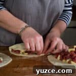 Authentic Cornish Pasty Recipe: Traditional Step-by-Step Guide 21 womans hands making three Cornish pasties on a wooden kitchen counter