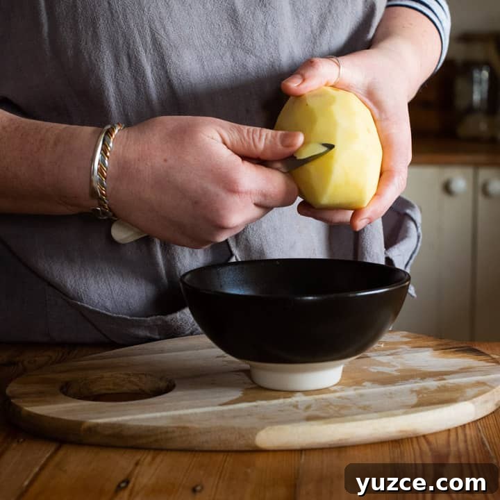 Authentic Cornish Pasty Recipe: Traditional Step-by-Step Guide 6 womans hands chipping a raw potato for making a pasty
