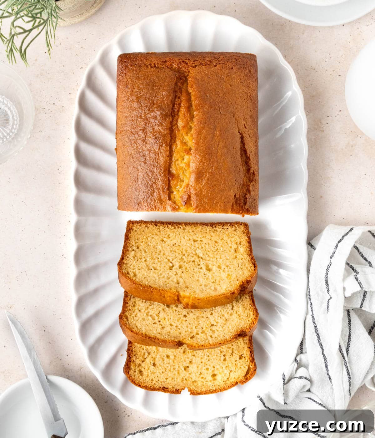 Classic French Yogurt Cake (Gâteau au Yaourt) Recipe 6 Loaf seen from above on an oval tray with 3 slices cut out.