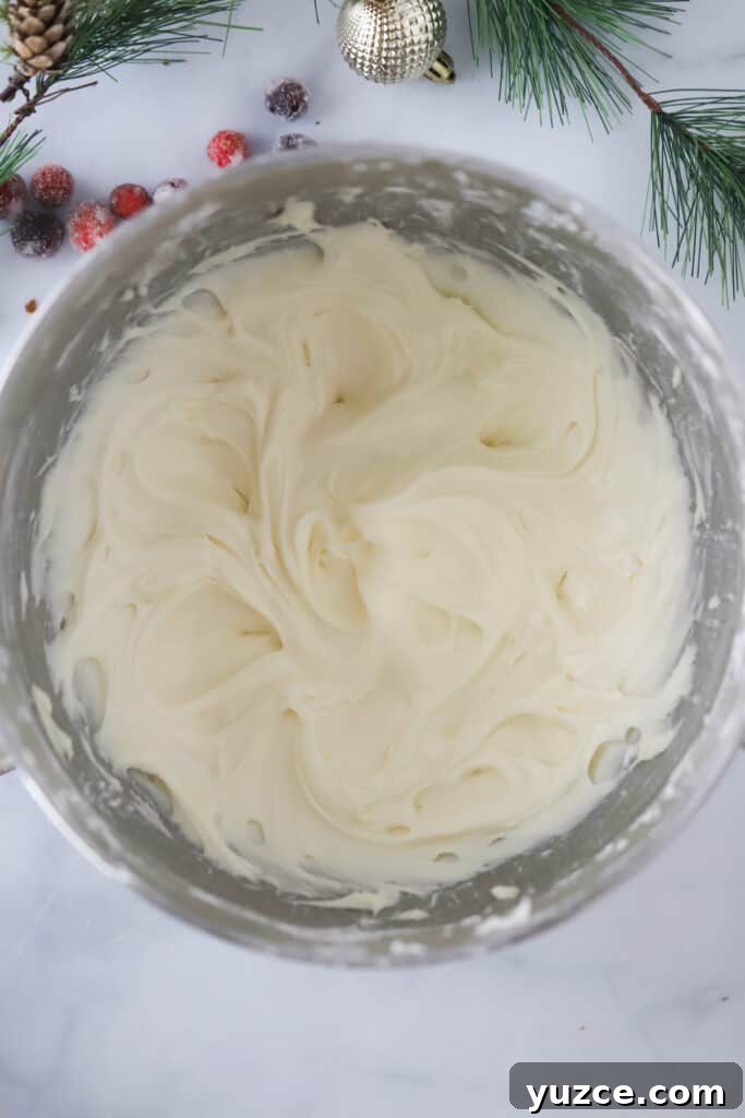 The best cream cheese frosting recipe in a mixing bowl, perfect cream cheese icing recipe for cinnamon rolls, carrot cake frosting recipe, and more.