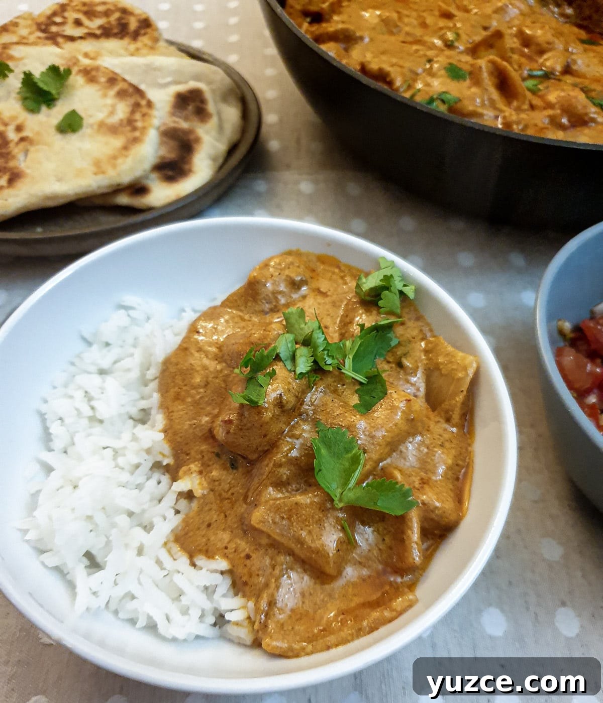 Creamy Murgh Makhani (Authentic Butter Chicken Recipe) 2 A serving of butter chicken on rice in a white dish.