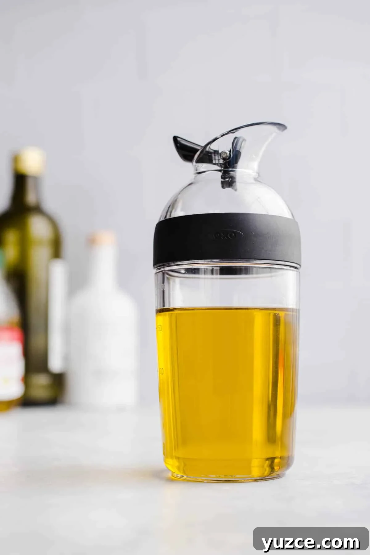A bottle with a spout filled with oil.