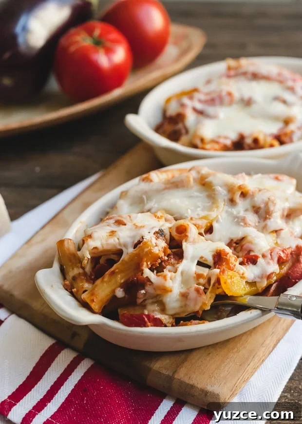 Baked Ziti with Roasted Eggplant and Peppers in a white baking dish.