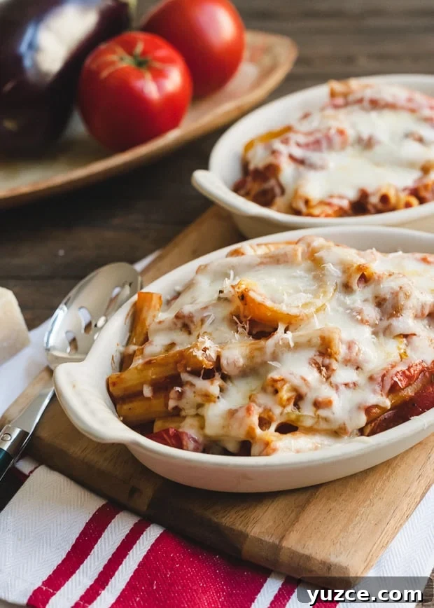 Portions of Baked Ziti with Roasted Eggplant and Peppers in white baking dishes.