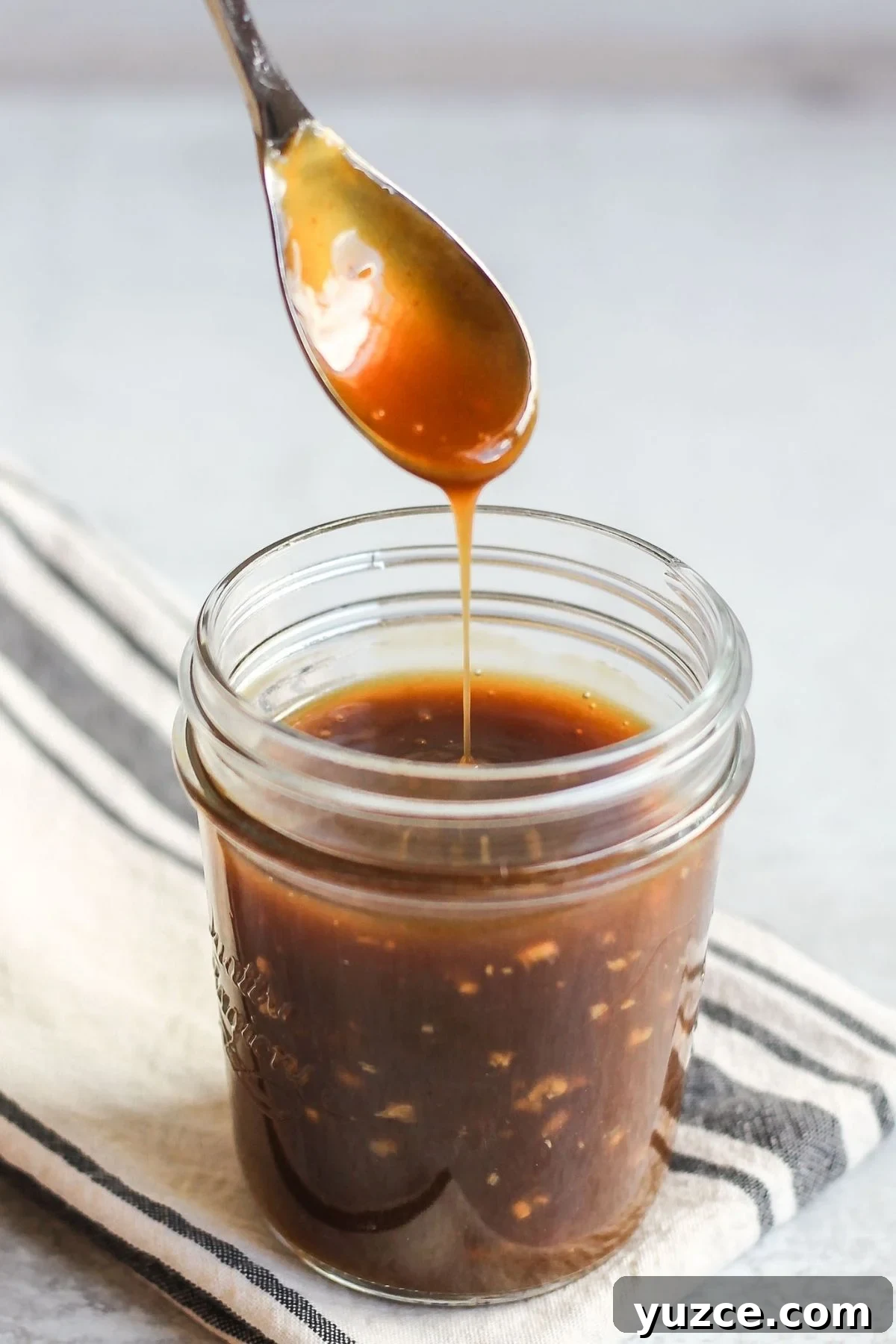 Soy-Free Teriyaki Sauce with Coconut Aminos — Quick Recipe 2 Teriyaki sauce dripping from a spoon over a mason jar filled with teriyaki