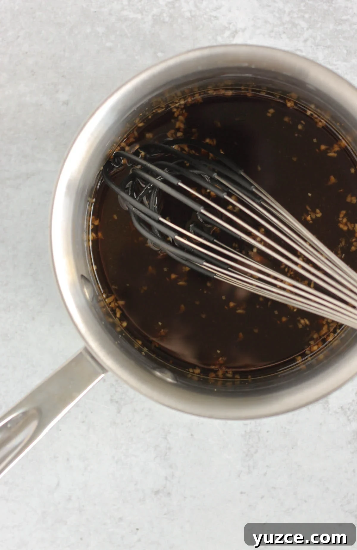 Soy-Free Teriyaki Sauce with Coconut Aminos — Quick Recipe 4 A whisk in a sauce pan filled with teriyaki sauce ingredients.
