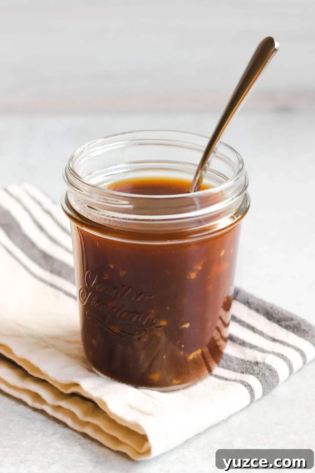 Soy-Free Teriyaki Sauce with Coconut Aminos — Quick Recipe 7 A spoon in a mason jar filled with teriyaki sauce.