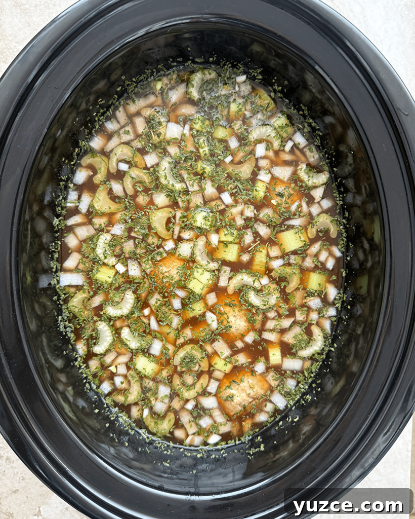 overhead shot of uncooked Meatball Tortellini Soup in a black slow cooker