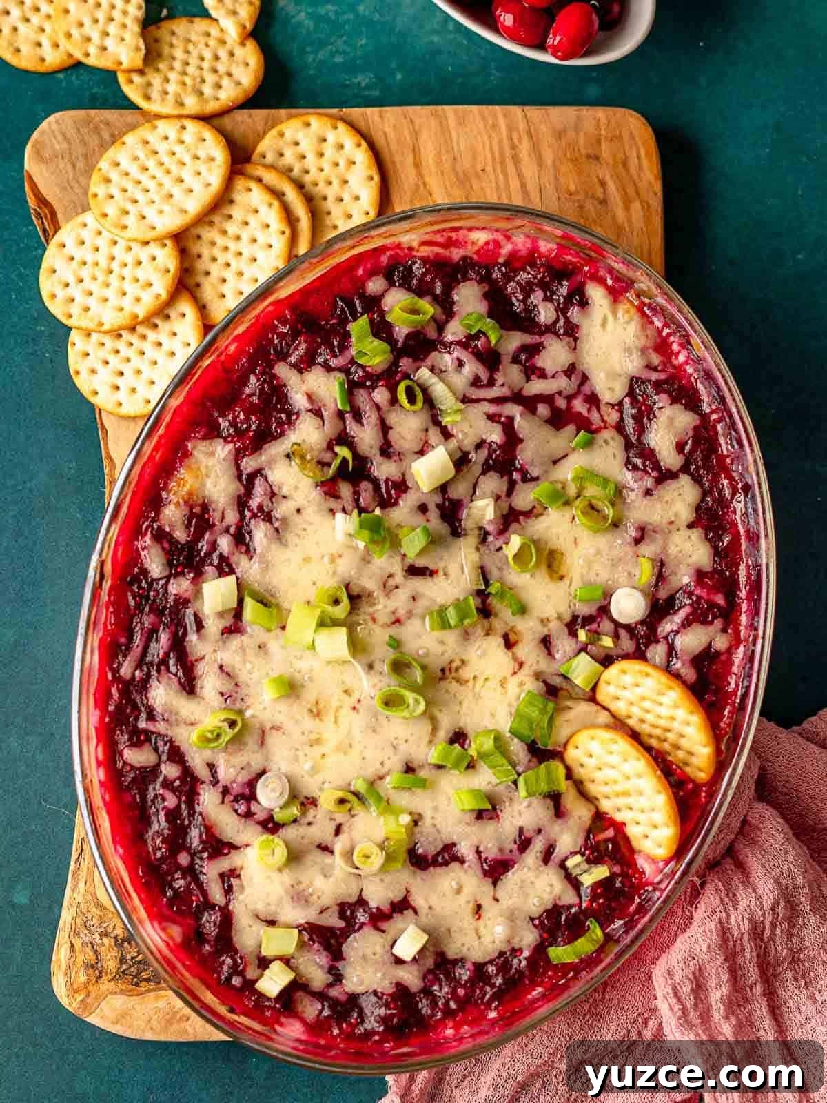 Cranberry Jalapeño Cream Cheese Dip Recipe for Holiday Parties 2 Crackers stuck in cranberry jalapeño cream cheese dip.