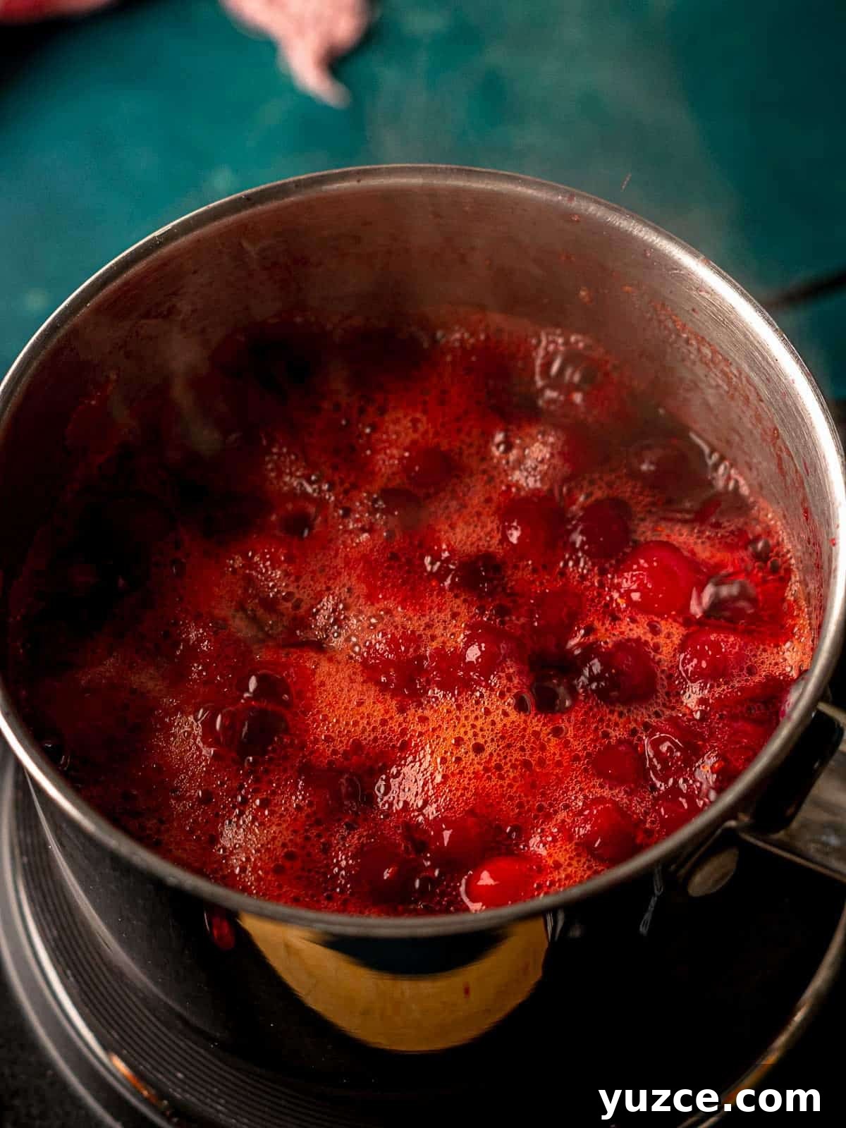 Cranberry Jalapeño Cream Cheese Dip Recipe for Holiday Parties 5 Cranberries simmering in a saucepan.