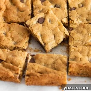 Gluten-Free Blondies Recipe: Chewy Vanilla Brownies 9 A close up of blondies sliced in a sheet pan, with one piece placed on top of the others