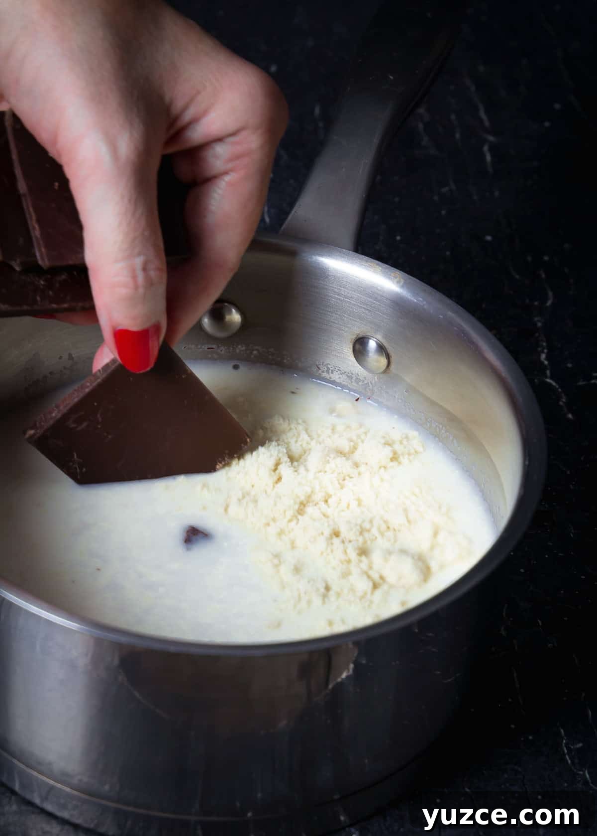 Oaxacan Hot Chocolate (Xocolatl): Authentic Mexican Recipe 4 Adding chocolate to the milk with almond meal in a pot.