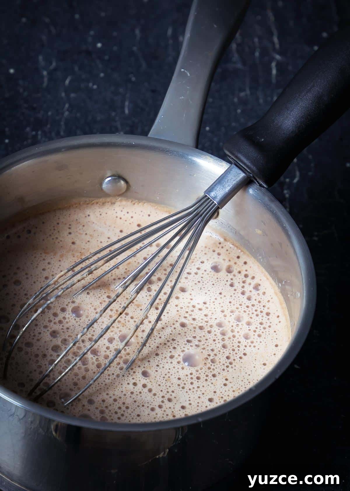 Oaxacan Hot Chocolate (Xocolatl): Authentic Mexican Recipe 5 A pot with all ingredients for xocolatl and a whisk on the stove.