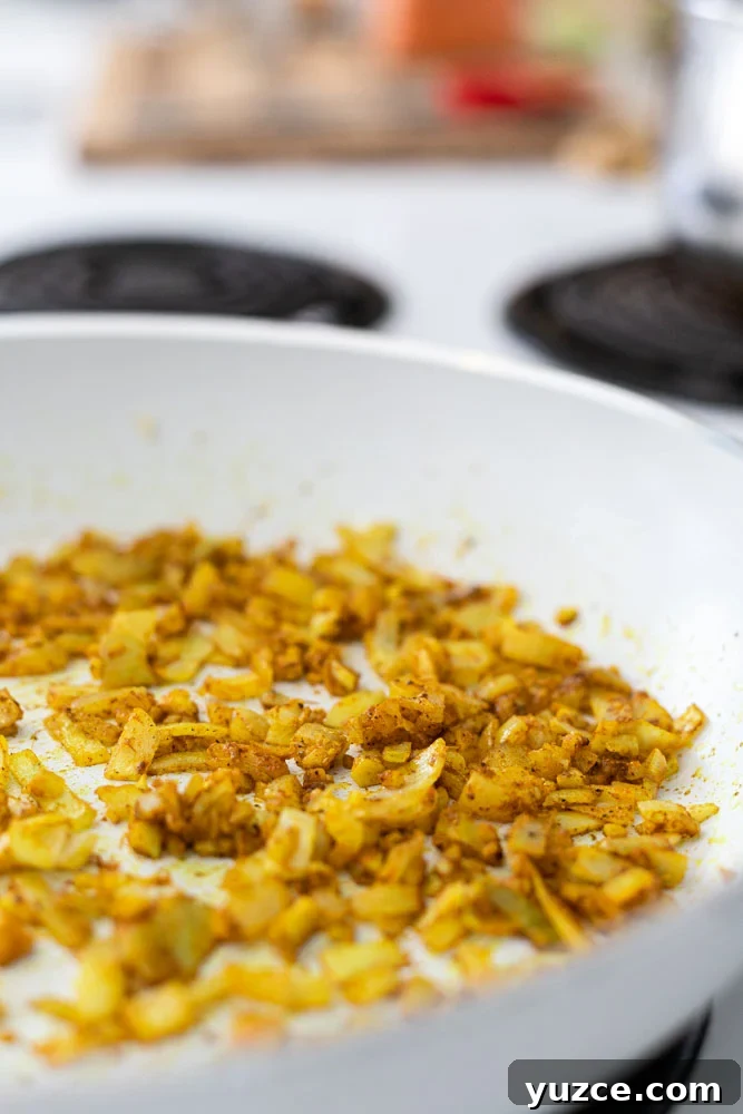 Creamy Red Lentil Curry Recipe with Coconut and Spices 3 Sautéing onions, garlic and spices in a skillet.