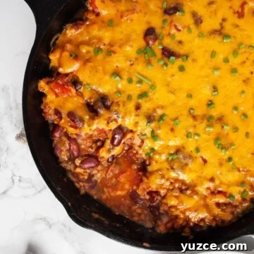 A close up of lentil casserole in a cast iron skillet.