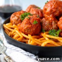Gluten-Free All-Beef Meatballs Without Breadcrumbs 7 meatballs served over pasta in a black bowl.