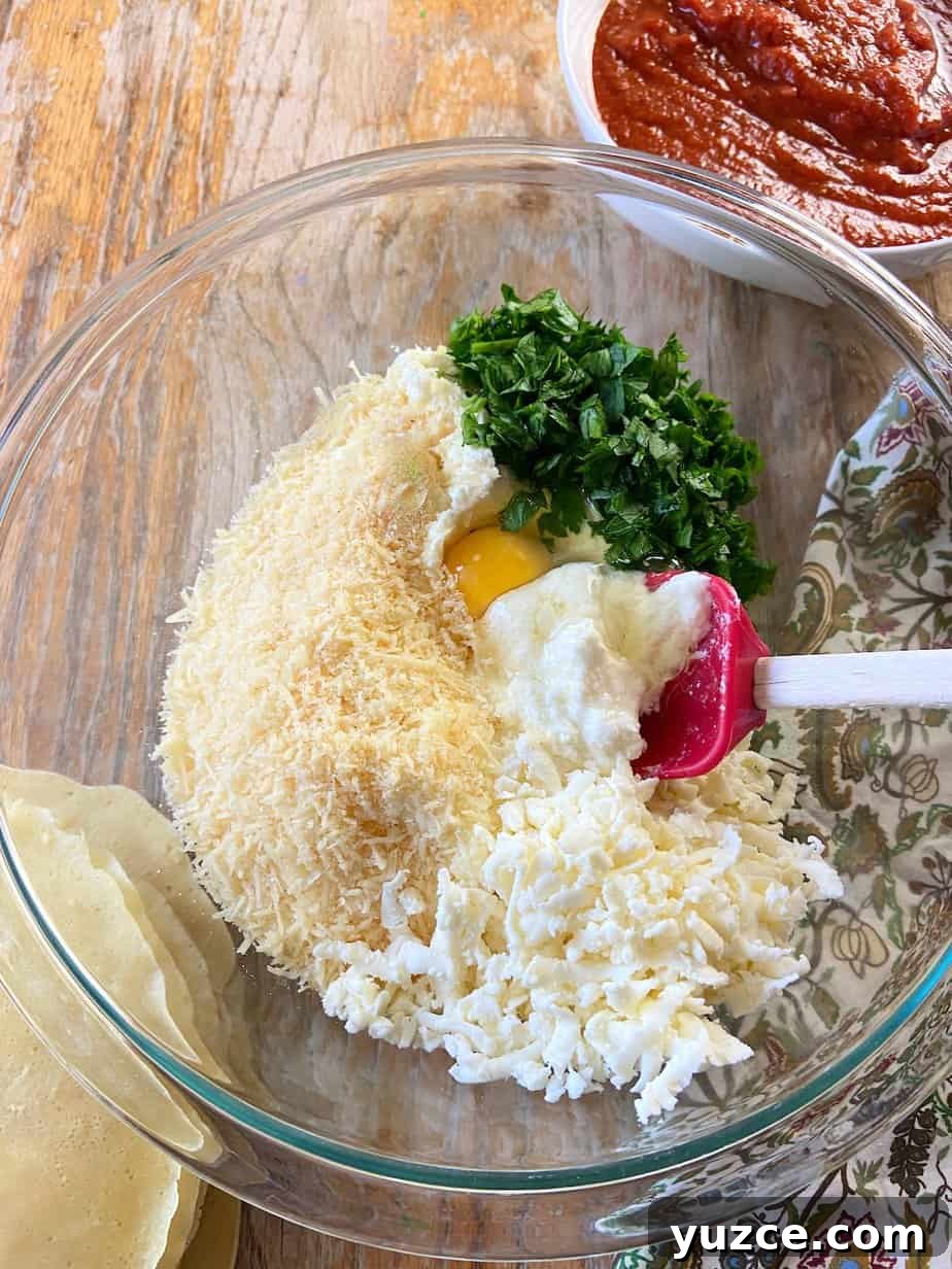 Three-Cheese Manicotti Crepes: Stuffed Italian Recipe 4 Ricotta, parmesan, mozzarella cheese, fresh parsley and one egg in glass mixing bowl.