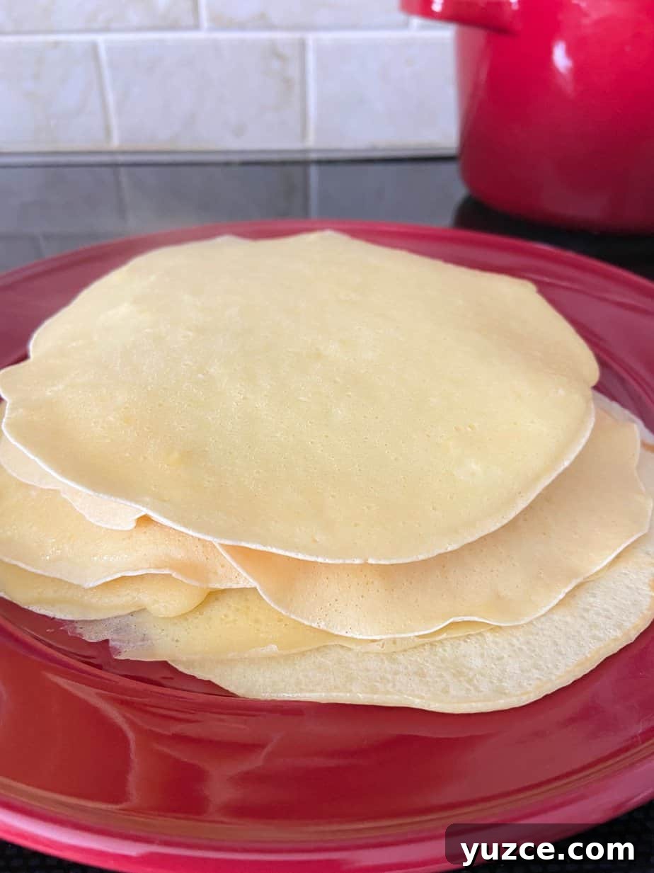Three-Cheese Manicotti Crepes: Stuffed Italian Recipe 5 Crepes stacked on a red plate.