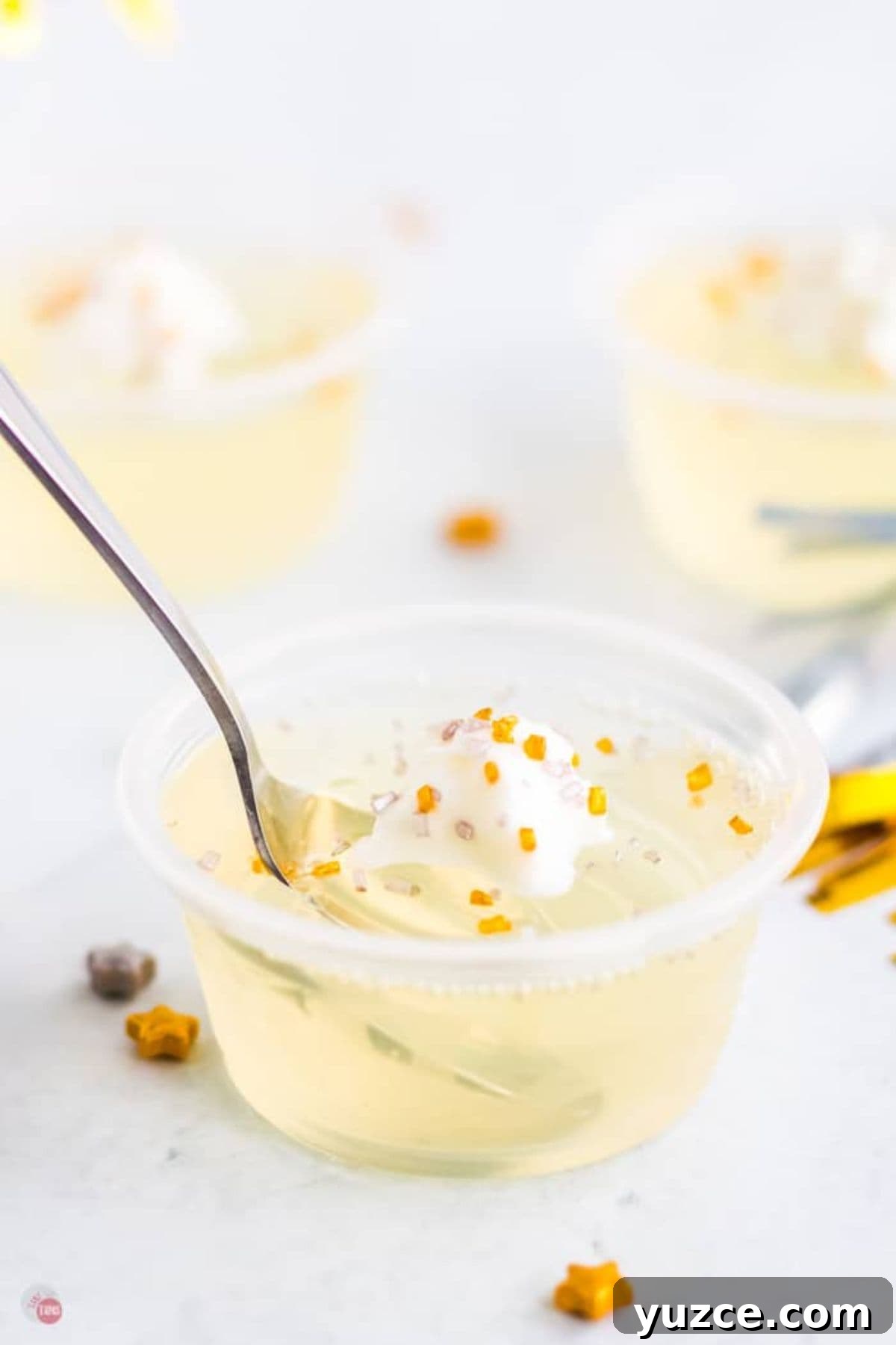 Champagne Jello Shots Recipe: Fizzy Party Cocktail Bites 7 jello shot with a spoon in it