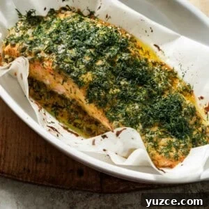 Dijon-Baked Salmon with Fresh Dill and Lemon 11 Dijon mustard dill salmon after being cooked in a baking dish with parchment paper.