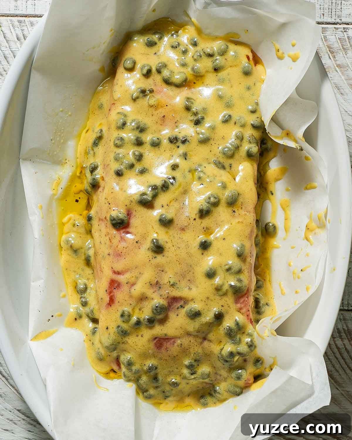 Dijon-Baked Salmon with Fresh Dill and Lemon 5 Dijon mustard marinade over salmon in a baking dish before baking.