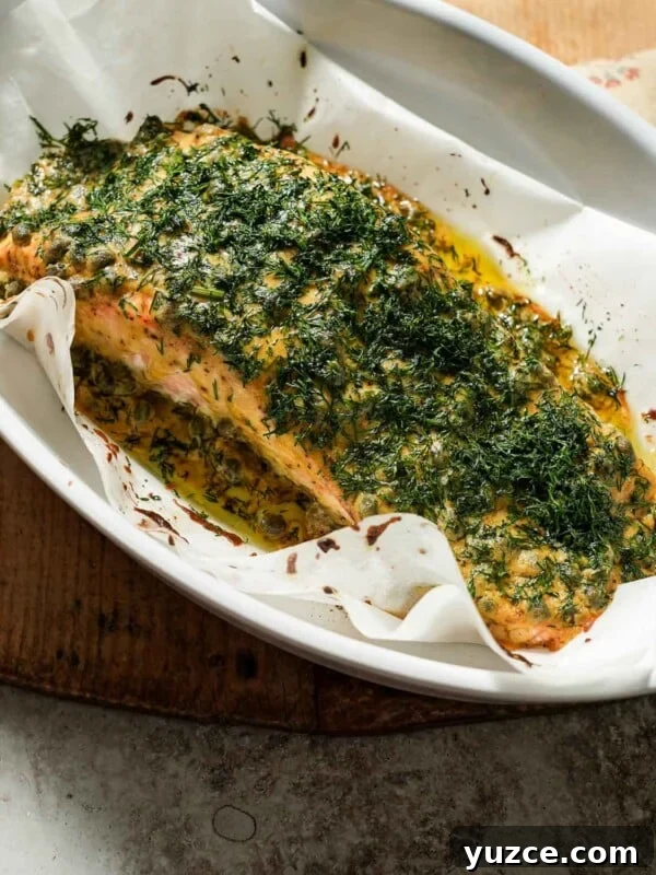 Dijon-Baked Salmon with Fresh Dill and Lemon 7 Dijon mustard dill salmon after being cooked in a baking dish with parchment paper.