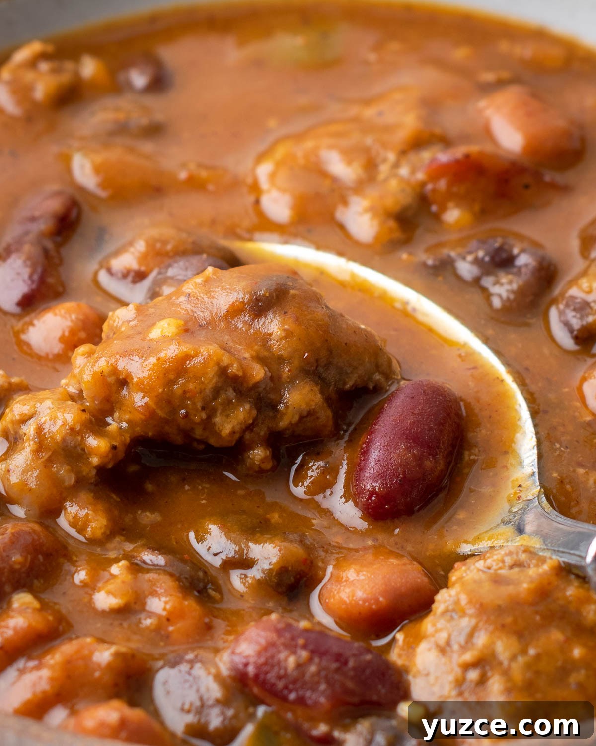 Spiced Pumpkin Chili with Turkey and Beans 8 A spoon scooping up a bit of pumpkin chili from a serving bowl.