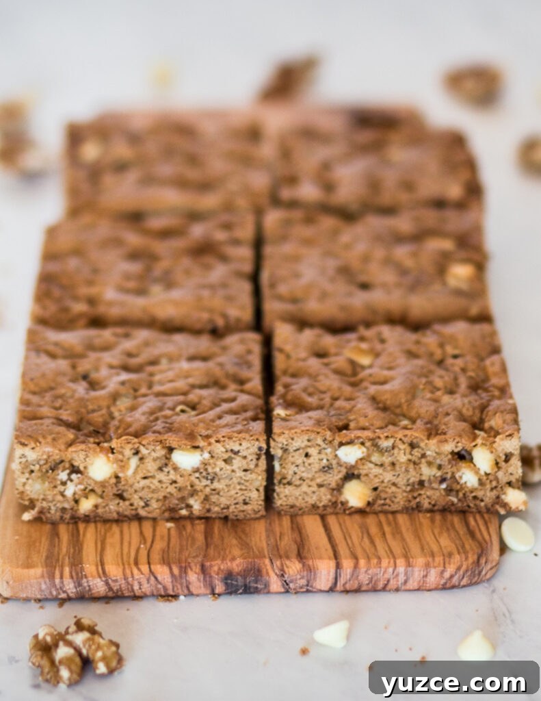 Gluten-Free White Chocolate Blondies Recipe for Chewy, Fudgy Bars 3 gluten free white chocolate blondies cut into square bars and laid on a wooden cutting board