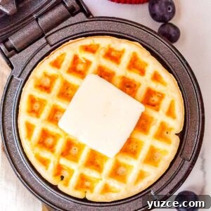 Crispy Dash Waffle Maker Recipes for Quick Breakfasts 7 The finished Dash waffle make recipe in the waffle maker with a pad of butter on top of the waffle.